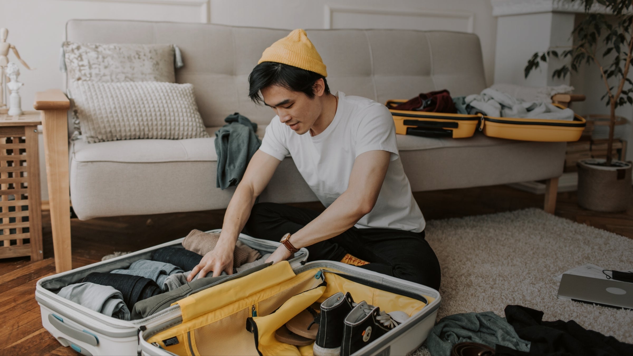 Person packing a suitcase in a living room